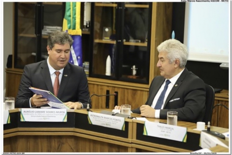 À esquerda o professor Aurélio Lamare segurando um papel e apresentando ao Ministro Marcos Pontes, que está à direita. 