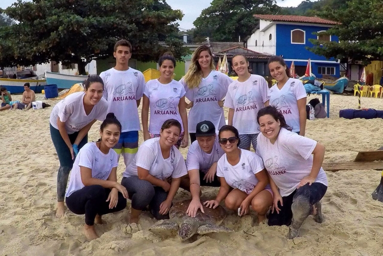 Integrantes do Projeto Aruanã com tartaruga marinha em Itaipu 