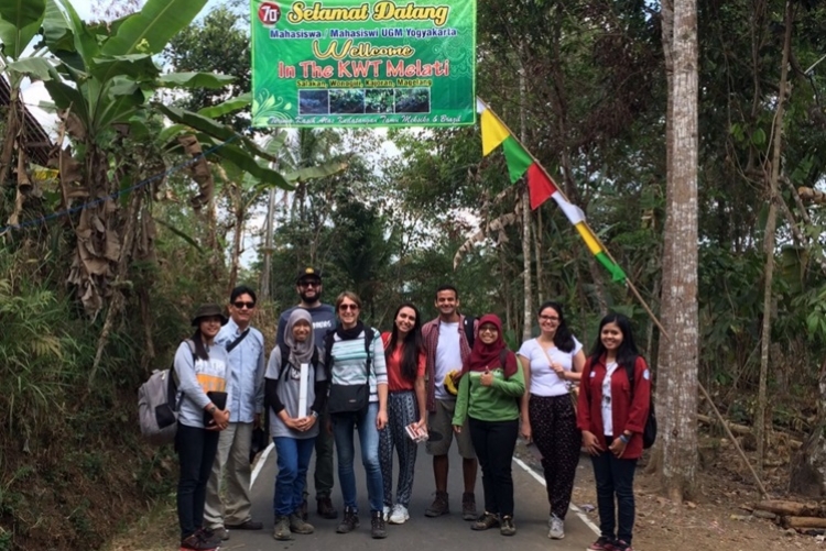 Equipe “Landslide” sob um cartaz feito pela Vila em homenagem aos estudantes