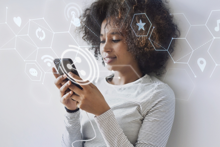 Mulher negra com celular na mão acessando à internet. Ícones simbolizando o acesso em redes encontram-se no layout na cor branca.