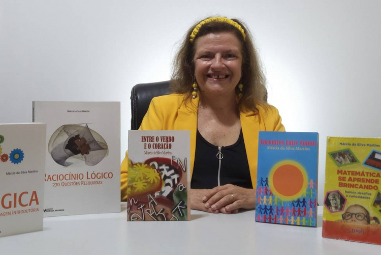Professora Marcia Martins com seus livros sobre Matemática