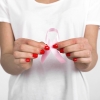 imagem: mãos segurando uma fita rosa, que é o símbolo da campanha outubro rosa
