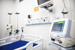  #ParaTodosVerem cama hospitalar azul e branca entre aparelhos de monitoramento de pacientes.