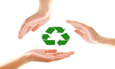 Mãos de pessoas envolvendo o símbolo da reciclagem