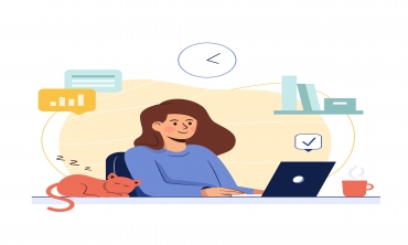 imagem de uma mulher de pele calara, cabelos marrons e blusa azul, trabalhando em escritório com um gato sentado na bancada