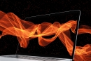 Imagem de uma tela de um laptop sendo atravessadas por ondas luminosas alaranjadas