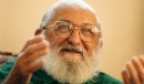 Paulo Freire sorrindo com as mãos levemente suspensas