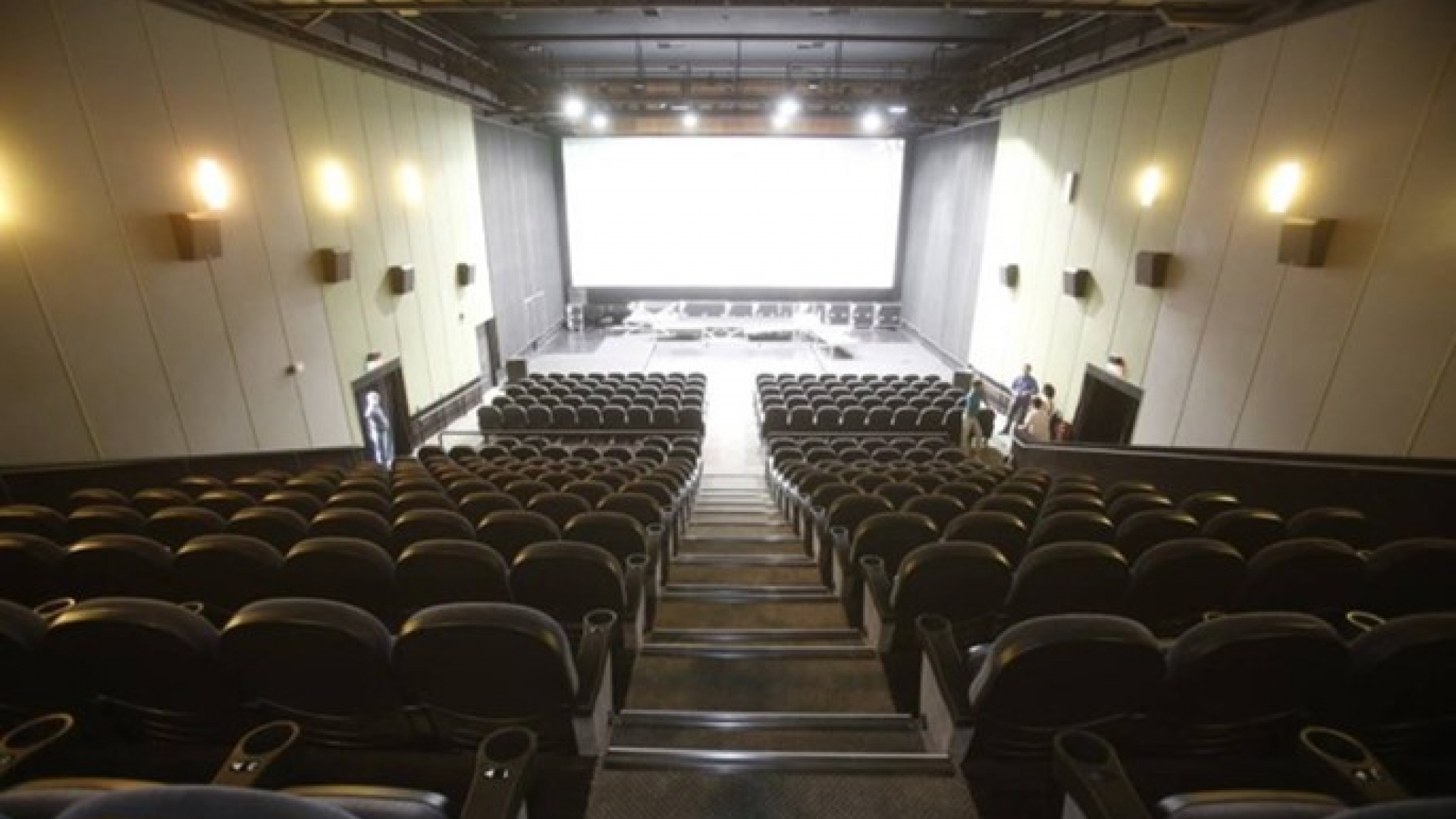 Centro de Artes UFF visto da plateia, com a imagem das fileiras de cadeiras e a tela ao fundo