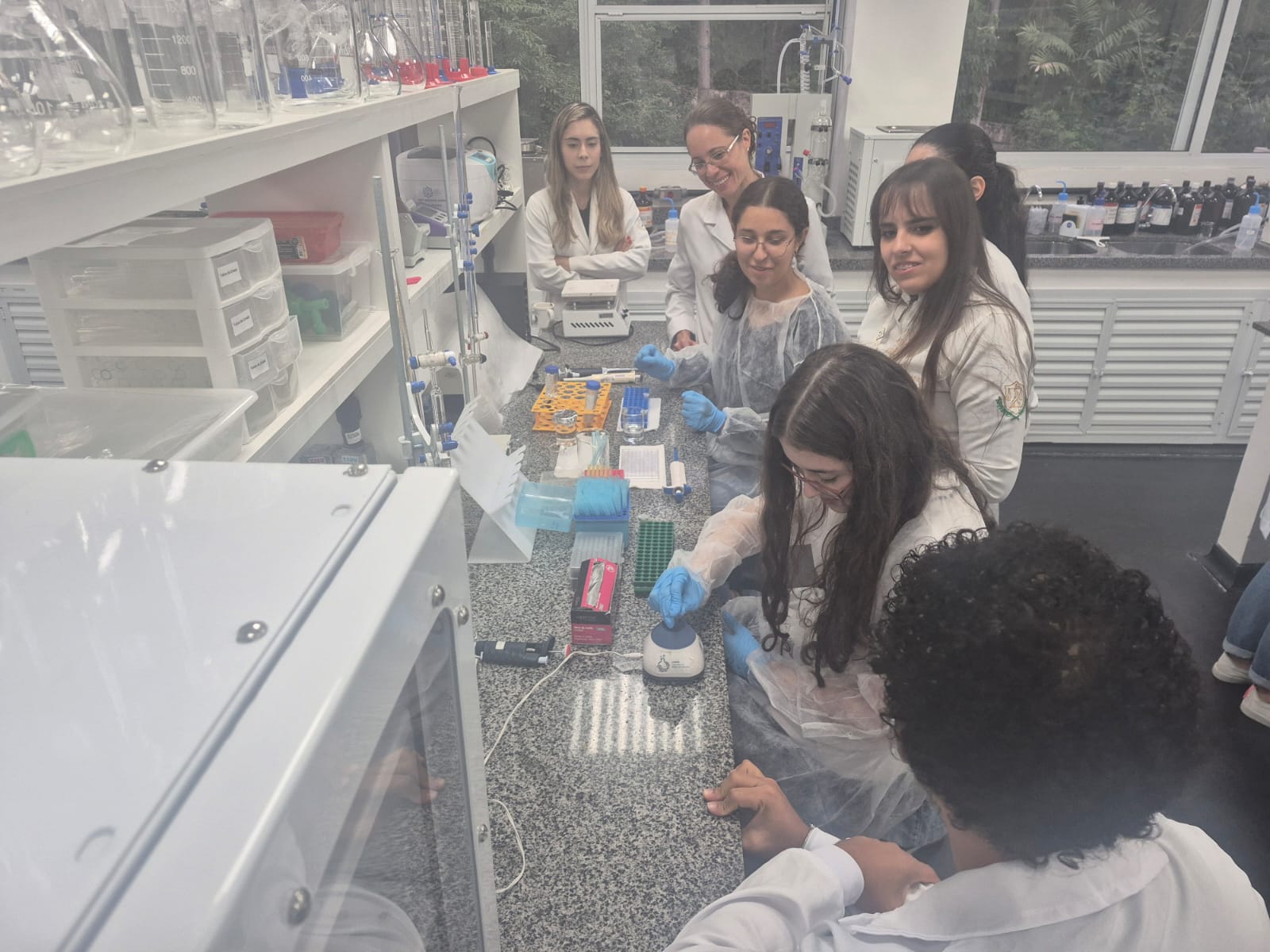 Foto de um grupo de jovens em laboratório fazendo experimentos