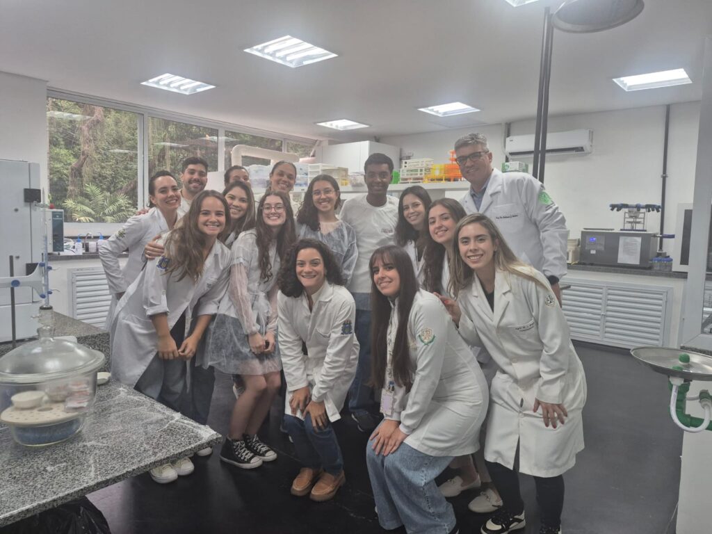 grupo de jovens de jaleco branco posando para foto