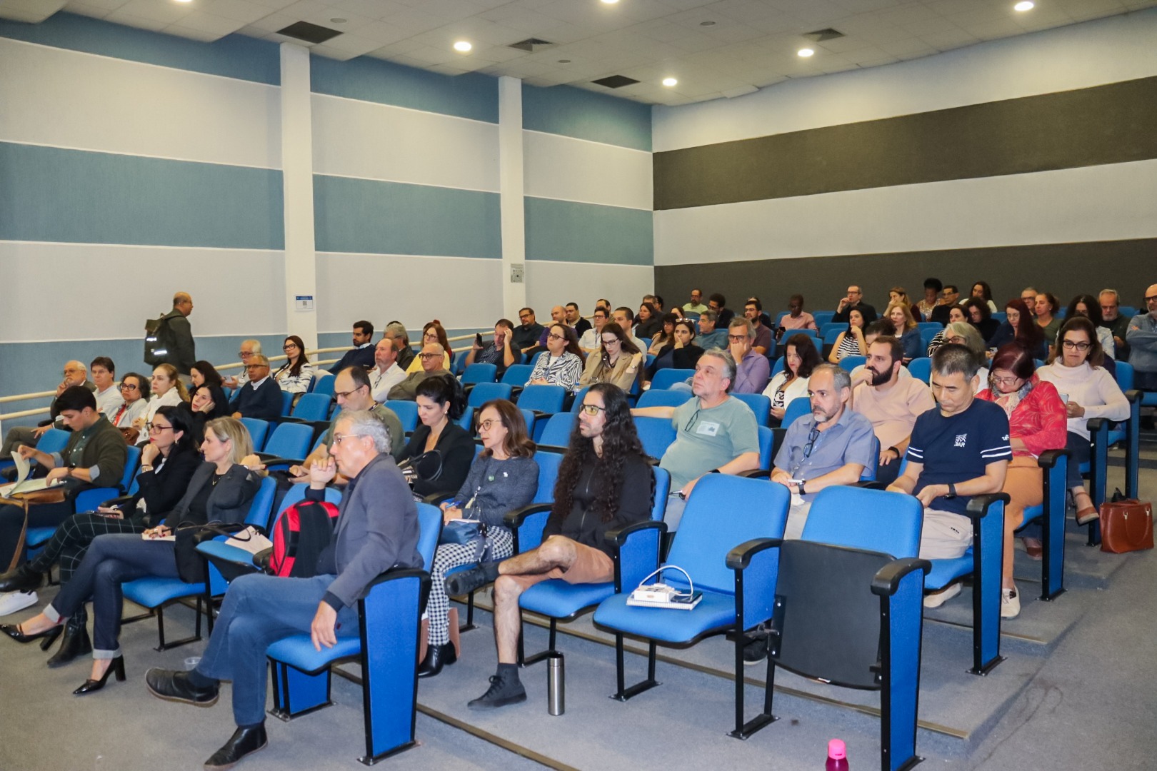 Foto tirada do funda sala, mostrando o palco e a audiência