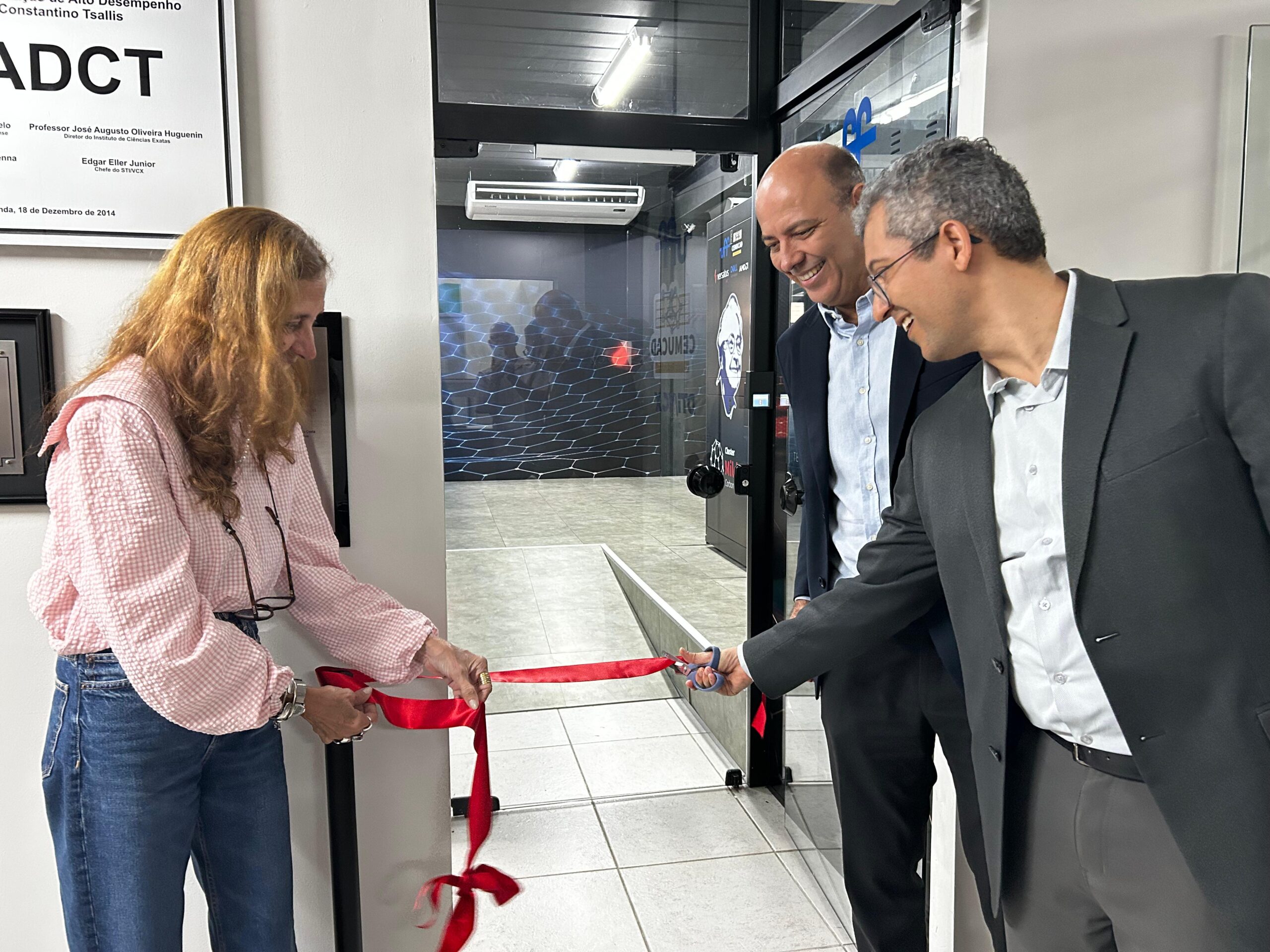 Inauguração Cemucad Foto de uma mulher cortando um fita vermelha de um lado e dois homens do outro