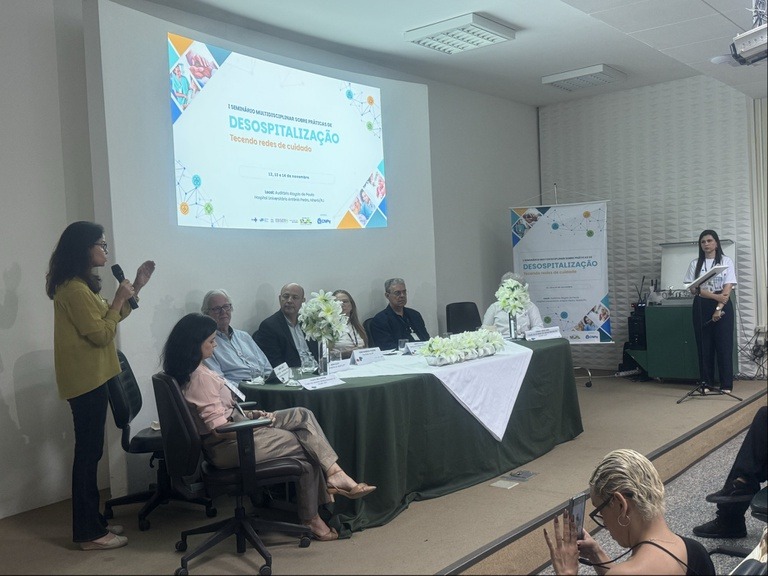 Foto da mesa de abertura do evento com profissionais da saúde